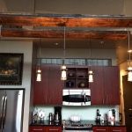 Railcar planks used as base for hanging kitchen pendant lights